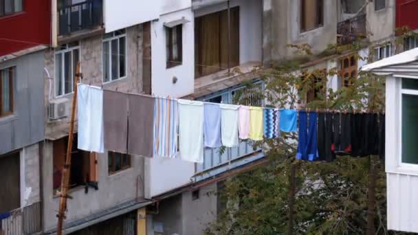Sušení prádla na prádelní šňůru mezi domy v chudé oblasti města. — Stock video