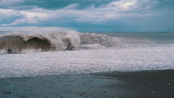 Tempestade no mar. Ondas enormes estão batendo e pulverizando na praia. Movimento lento — Vídeo de Stock