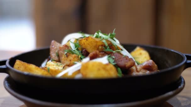Ojahuri, ψήνονται πατάτες με κρέας σε ένα τηγάνι σε ένα ξύλινο τραπέζι σε ένα εστιατόριο γεωργιανό — Αρχείο Βίντεο