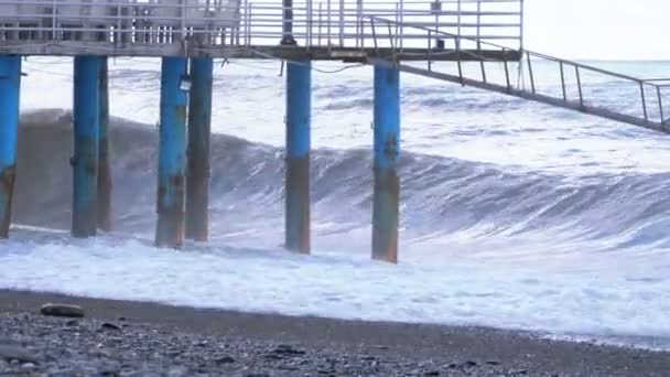 Морской шторм. Большие волны разбиваются на пирсе возле берега — стоковое видео