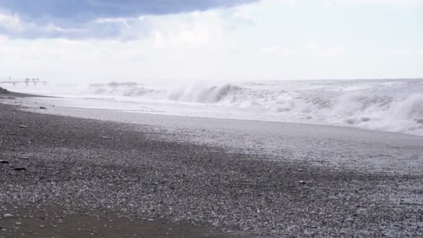 Tempête sur la mer. D'énormes vagues s'écrasent et pulvérisent sur la plage. Mouvement lent — Video