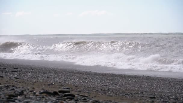 Tempestade no mar. Ondas enormes estão batendo e pulverizando na praia. Movimento lento — Vídeo de Stock