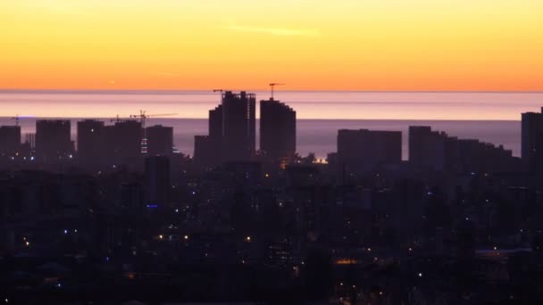 Vista aérea de las siluetas de los rascacielos contra la puesta de sol en la gran ciudad — Vídeo de stock