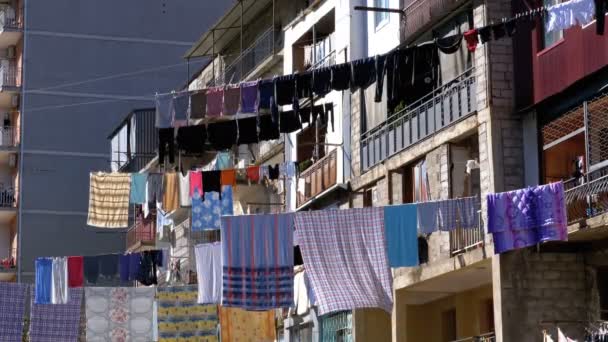 Ropa colgada y secada en una cuerda en un edificio de varios pisos en un barrio pobre de la ciudad — Vídeo de stock