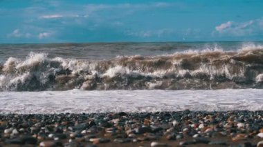Deniz fırtınası. Büyük dalgalar kilitlenme ve ilaçlama plaj vardır. Ağır çekimde 180 fps. Alt görünümü Stony kıyı. Doğanın güçlü gücü büyük dalgalar kıyıya çöker. Binbaşı şiddetli