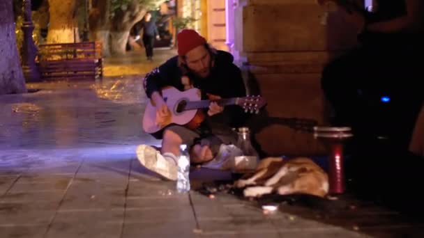 城市里的街头音乐家晚上弹吉他 — 图库视频影像
