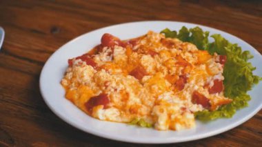 Domates, peynir ve bir restoranda ahşap bir masa üzerinde otlar ile Gürcü omlet tabak.