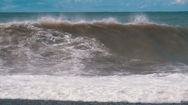 Tempête sur la mer. D'énormes vagues s'écrasent et pulvérisent sur le rivage. Mouvement lent 