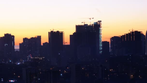 Vista aérea das silhuetas dos arranha-céus contra o pôr do sol na cidade grande — Vídeo de Stock