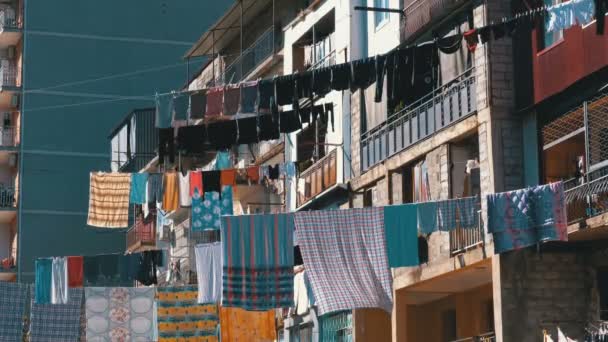 Secar la ropa en un tendedero entre casas en una zona pobre de la ciudad . — Vídeo de stock