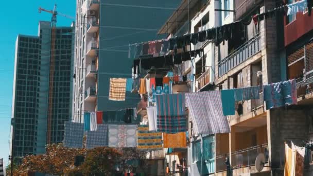 Secagem de roupas em um varal entre casas em uma área pobre da cidade . — Vídeo de Stock