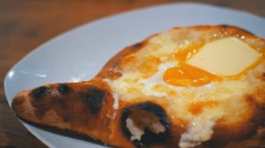 Acara Khachapuri restoranda bir tabakta yumurta ile