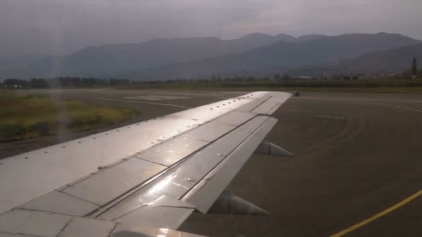 从降落后沿机场跑道行驶的飞机机翼的窗户上看风景 — 图库视频影像