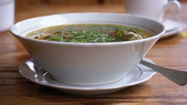 Placa de sopa tradicional georgiana de Khashlama sobre una mesa de madera en un restaurante — Vídeos de Stock