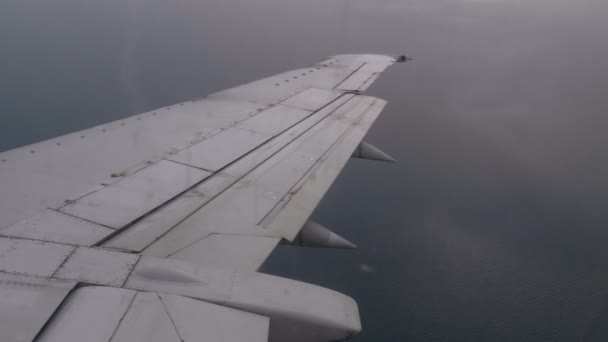 Uitzicht uit het raam van de vliegtuig passagier op de vleugel vliegen boven de wolken — Stockvideo