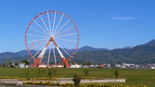 La ruota panoramica nel pomeriggio sullo sfondo delle montagne e l'argine di Batumi — Video Stock