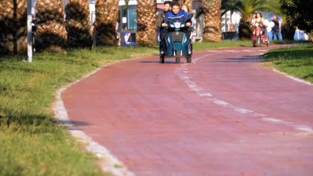 Eople Montar una vespa eléctrica de tres ruedas en el carril bici en el parque — Vídeo de stock