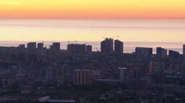 Gökdelenlerin siluetleri, gün batımına karşı büyük şehrin havadan görünümü
