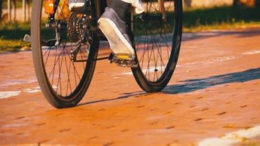 Adam bir 3 tekerlekli elektrikli bisiklet yolu Park üzerinde sürme. Ağır çekim