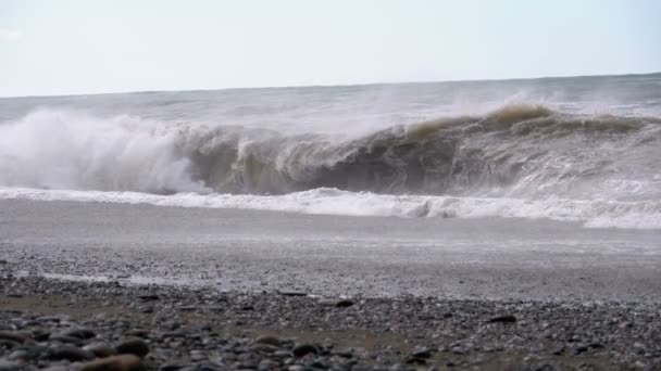 Tempesta sul mare. Onde enormi si stanno schiantando e spruzzando sulla spiaggia. Rallentatore — Video Stock