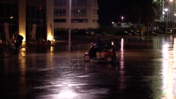 Adam Batum dolgu üzerinde geceleri bir 3 tekerlekli elektrikli scooter üzerinde sürüklenen. — Stok video