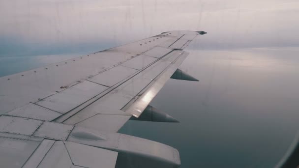 Vue depuis la fenêtre de l'avion à passagers de l'aile survolant les nuages 