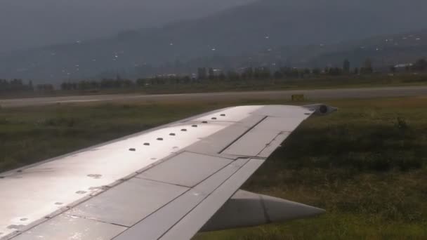 Pohled z okna na křídle letadla pohybující se podél ranveje na letišti po přistání
