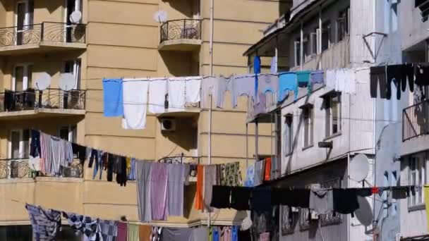 Одежда висит и сушится на веревке на многоэтажном здании в бедном районе города — стоковое видео
