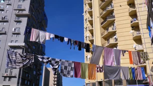 Ropa colgada y secada en una cuerda en un edificio de varios pisos en un barrio pobre de la ciudad — Vídeo de stock