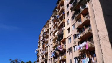 Clothesline üzerinde şehrin yoksul bir alanda yüksek katlı eski ev balkon arasında elbise kurutma