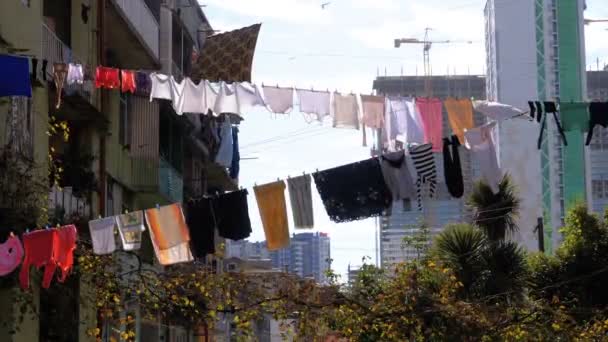 Одежда висит и сушится на веревке на многоэтажном здании в бедном районе города — стоковое видео