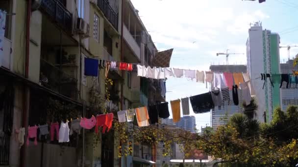 Roupas penduradas e secando em uma corda em um prédio de vários andares em um bairro pobre da cidade — Vídeo de Stock