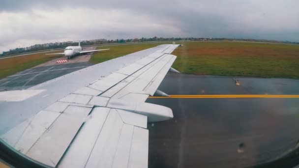 Θέα από το παράθυρο στο φτερό ενός αεροπλάνου που κινείται κατά μήκος του διαδρόμου στο αεροδρόμιο — Αρχείο Βίντεο
