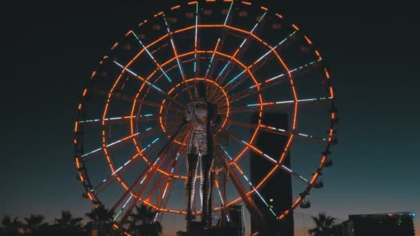 Estatua de Ali y Nino sobre un fondo Rueda de la fortuna en la noche en el terraplén de Batumi, Georgia — Vídeos de Stock