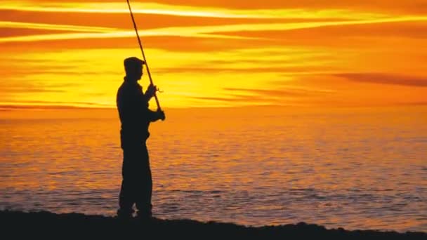 Silhouette Eines Fischers Mit Angelrute Bei Sonnenuntergang Über Dem Meer — Stockvideo