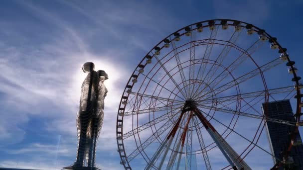 Staty av Ali och Nino och pariserhjul mot the Bright Sun på banvallen av Batumi, Georgien — Stockvideo