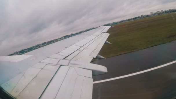 Uitzicht uit het raam op de vleugel van een passagiersvliegtuig tijdens het opstijgen — Stockvideo