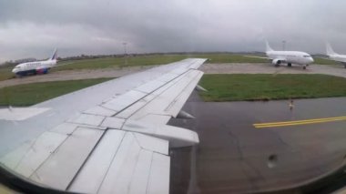 Havaalanı pist boyunca hareketli bir uçağın kanat penceresinde göster