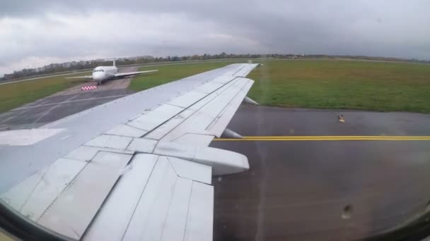 Вид из окна на крыло самолета, двигающегося по взлетно-посадочной полосе аэропорта — стоковое видео