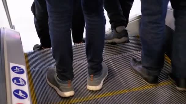 Beine von Menschen, die sich auf einer Rolltreppe in einem Einkaufszentrum bewegen — Stockvideo