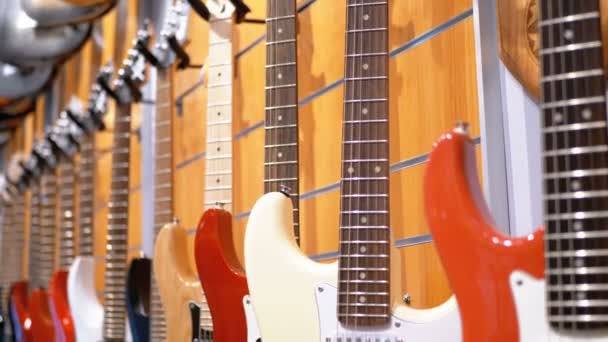 Wiele gitar elektrycznych, wiszące w sklepie muzycznym. Instrumenty muzyczne sklep — Wideo stockowe