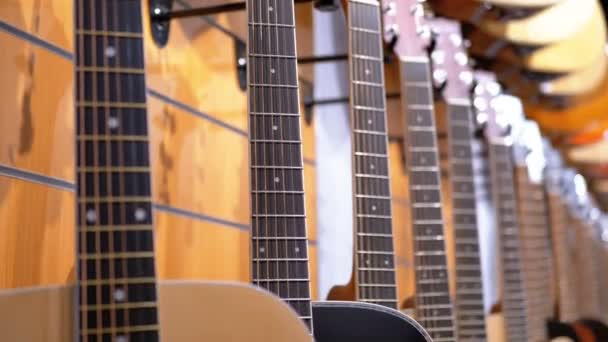 Muchas guitarras acústicas colgando en una tienda de música. Tienda instrumentos musicales . — Vídeo de stock