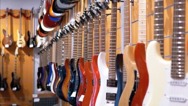 Viele E-Gitarren hängen in einem Musikladen. Musikinstrumente kaufen — Stockvideo