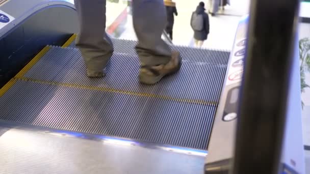 Personas anónimas caminando en el ascensor de escaleras mecánicas en el centro comercial. Moción lenta — Vídeos de Stock