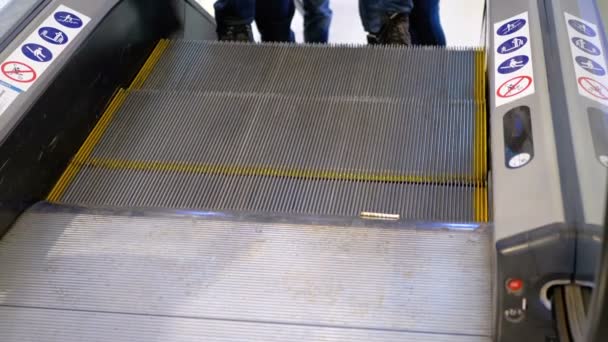 Beine von Menschen, die sich auf einer Rolltreppe in einem Einkaufszentrum bewegen. Zeitlupe — Stockvideo