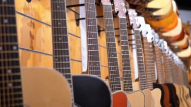 Birçok akustik gitar müzik mağazada asılı. Dükkanı müzik aletleri.