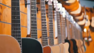 Birçok akustik gitar müzik mağazada asılı. Dükkanı müzik aletleri.