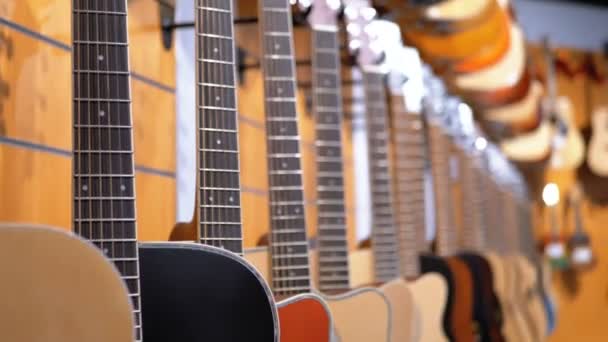 Muchas guitarras acústicas colgando en una tienda de música. Tienda instrumentos musicales . — Vídeo de stock