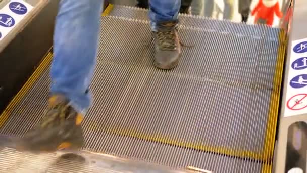 Ноги людей движутся на эскалаторе лифта в торговом центре — стоковое видео