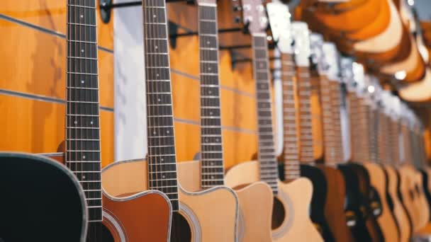 Muchas guitarras acústicas colgando en una tienda de música. Tienda instrumentos musicales . — Vídeo de stock